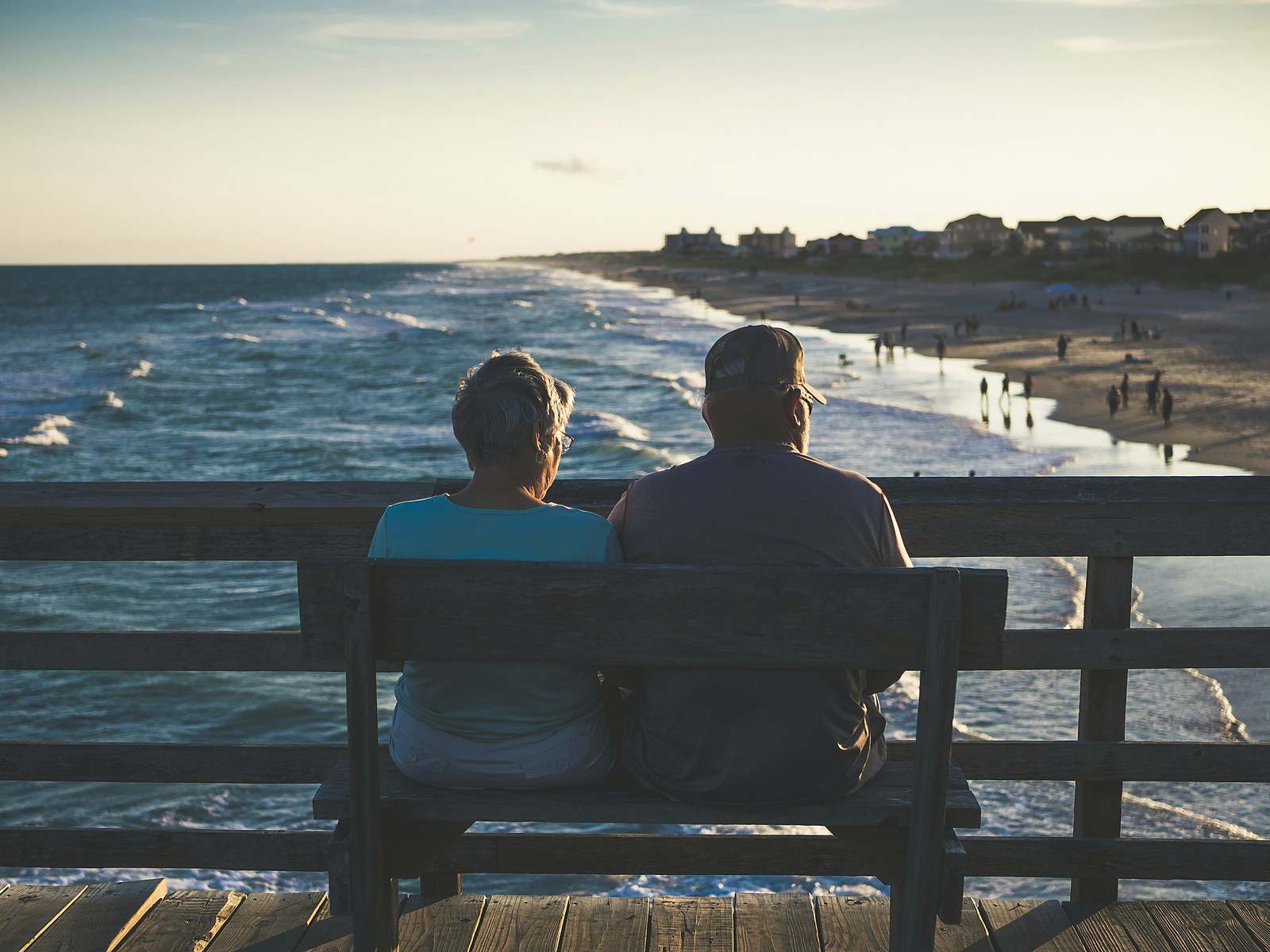 Older couple sitting on a bench overlooking the ocean