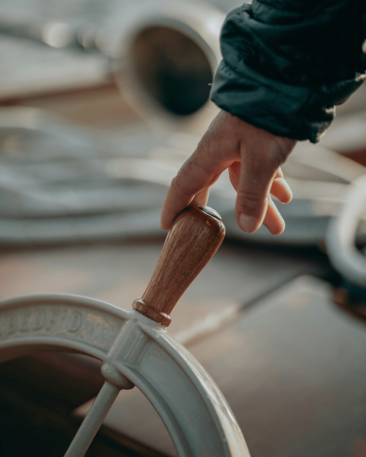A hand at the helm of a ship's wheel